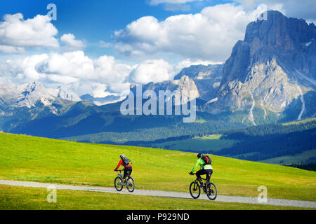 Les touristes à vélo dans la région de Alpe di Siusi, le plus grand prairie alpine de haute altitude en Europe, de superbes montagnes rocheuses en arrière-plan. Province du Tyrol du Sud Banque D'Images