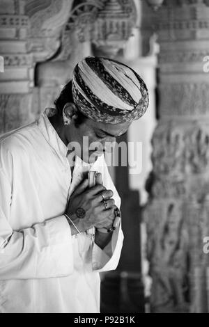 Un dévot Jain fait une prière à l'intérieur d'un temple Jain dans le FORT DE JAISALMER - RAJASTHAN, INDE Banque D'Images