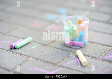 Les craies de couleur dans un seau sur un trottoir Banque D'Images