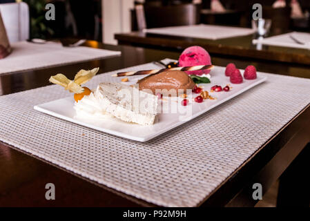 Morceau de mousse marron chocolat u un dessert sucré et décoration sur une plaque blanche background Banque D'Images