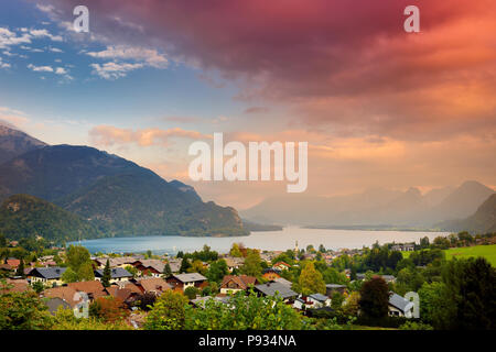 Coucher de soleil sur le pittoresque petit village autrichien de St Gilgen, situé sur le lac Wolfgangsee, avec de spectaculaires montagnes alpines sur l'arrière-plan. Banque D'Images