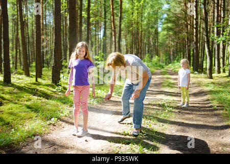 Femme d'âge moyen d'appliquer un insectifuge sur sa petite-fille avant de randonnée forêt belle journée d'été. La protection des enfants contre les insectes piqueurs du su Banque D'Images