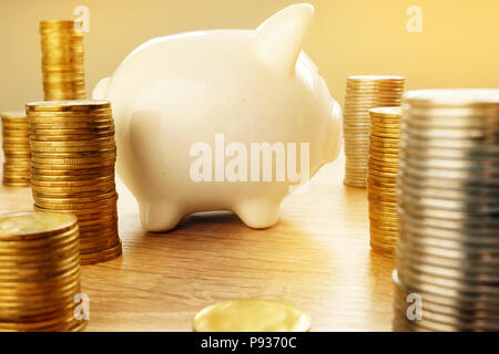 L'épargne et de la richesse. Tirelire et des piles de pièces. Banque D'Images