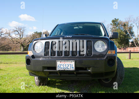 Jeep Patriot noir véhicule utilitaire sport (VUS) dans l'air extérieur avec fond naturel de la plaque d'immatriculation de la Californie - vue avant Banque D'Images