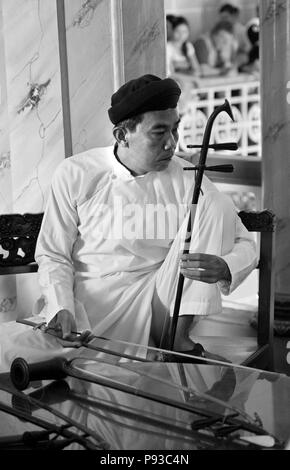 Adorateur laïcs à l'intérieur de l'erhu joue un grand temple de Cao Dai, VILLAGE TAY NINH, Vietnam Banque D'Images