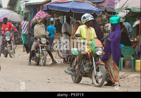 Kakuma, Kenya - Scène de rue avec des gens et les motos. Trafic moto sur une longue route non revêtue. Banque D'Images