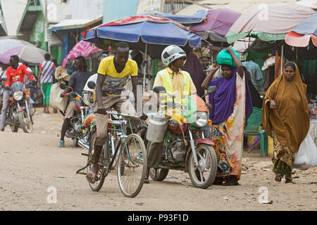 Kakuma, Kenya - Scène de rue avec des gens, des motos et vélos. Le trafic sur une route non revêtue. Banque D'Images