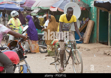 Kakuma, Kenya - Scène de rue avec des gens, des motos et vélos. Le trafic sur une route non revêtue. Banque D'Images