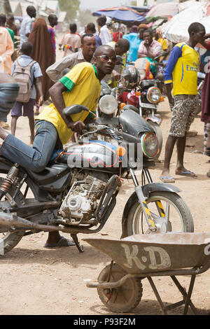 Kakuma, Kenya - Scène de rue avec des gens et les motos. Trafic moto sur une longue route non revêtue. Banque D'Images