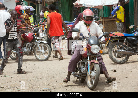 Kakuma, Kenya - Scène de rue avec des gens et les motos. Trafic moto sur une longue route non revêtue. Banque D'Images