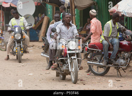 Kakuma, Kenya - Scène de rue avec des gens et les motos. Trafic moto sur une longue route non revêtue. Banque D'Images