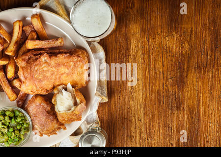 Le poisson dans la pâte traditionnelle de la bière et des frites avec petits pois et sauce tartare.vue d'en haut Banque D'Images