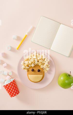 Des crêpes pour le petit-déjeuner. bébé Idée créative pour l'enfant dessert : de délicieuses crêpes dans la forme de la visage heureux, les cheveux faire du pop-corn Banque D'Images