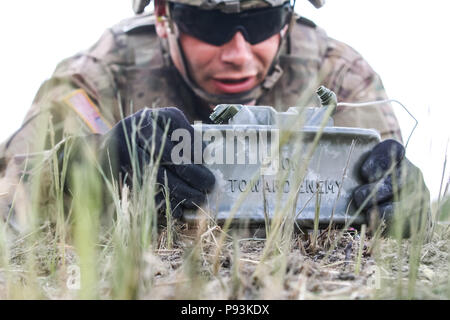 Un soldat de l'armée américaine avec 1er Escadron, 2e régiment de cavalerie, un emplaces M18A1 au cours d'une mine Claymore claymore multinationales d'entraînement avec le groupe de combat en Pologne Bemowo Piskie Domaine de formation, la Pologne le 10 juillet 2018. La Pologne est un groupe de combat, unique coalition multinationale d'États-Unis, Royaume-Uni, croate et soldats roumains qui servent avec la 15e Brigade mécanisée polonaise comme une force de dissuasion de l'OTAN à l'appui de l'amélioration de l'avant la Présence. (U.S. Photo de l'armée par la CPS. Hubert D. Delany III /22e Détachement des affaires publiques mobiles) Banque D'Images