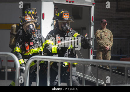 Les pompiers avec le New York City Fire Department (FDNY) prépare sa lance à incendie comme ils s'entraînent aux côtés des soldats de l'Armée américaine sur la façon de répondre à une urgence à grande échelle à New York City, New York, le 10 juillet 2018. Le FDNY le long de l'armée américaine avec l'armée américaine et du Commandement du Nord est la réalisation d'un exercice conjoint simulant un incident chimique, biologique, radiologique et nucléaire (CBRN) Événement pour maximiser la réponse appropriée à partir de la première réponse. (U.S. Photo de l'armée par la CPS. Brandon Best) Banque D'Images