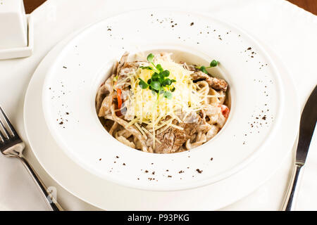 Les pâtes spaghetti à la viande, du fromage et des herbes en plaque blanche Banque D'Images