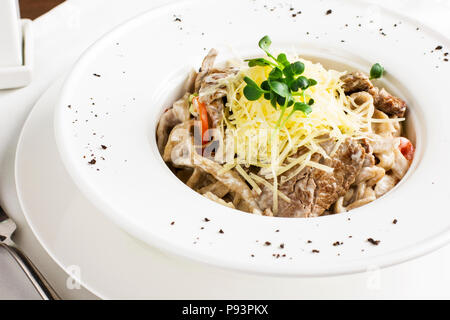 Les pâtes spaghetti à la viande, du fromage et des herbes en plaque blanche Banque D'Images