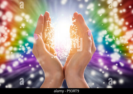 Close-up of a Woman's Hand Holding Light Against Colorful Background Banque D'Images