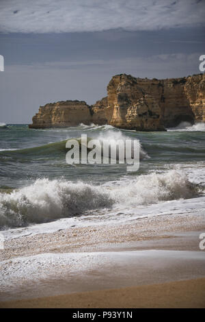 Serene côte de l'Algarve avec plage, océan, vagues et falaises de red rock. Banque D'Images