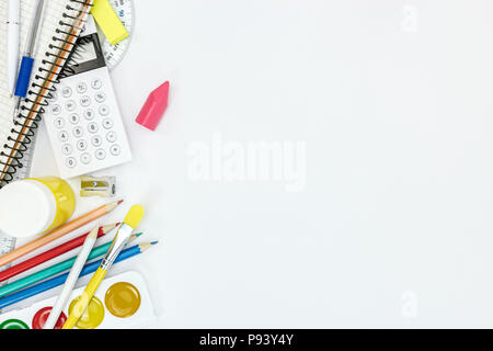 Les peintures à l'aquarelle, crayons, blocs-notes et autres articles de papeterie pour l'école sur fond blanc Banque D'Images