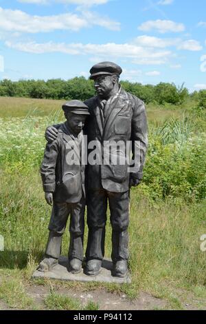 Sculpture en bois d'un mineur de charbon père et fils au parc La réserve naturelle de la mine de récupération 112 hommes et garçons ont perdu la vie Aberkenfig au Pays de Galles Banque D'Images