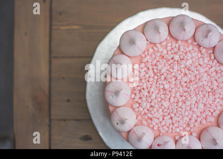 Pink Champagne gâteau avec mini meringues rose en haut, couvert d'arrose Banque D'Images