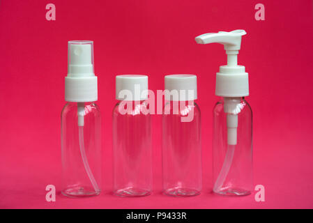 Ensemble de petites bouteilles vides des cosmétiques sur fond rose. Pour le savon, shampoing, gel douche, spray Banque D'Images