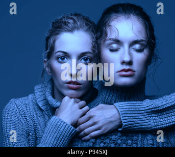 Beauté Halloween portrait de deux jeunes femmes dans les pulls gris gris sur fond de studio. Belles filles étend les mains en avant en étreinte. F femelle Banque D'Images