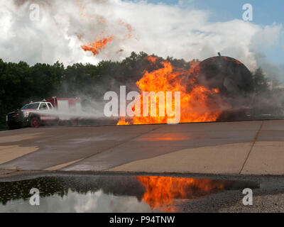 U.S. Air Force les pompiers éteindre un incendie de l'avion simulé à l'aide d'une mini-pumper squad au cours de l'Exercice PATRIOT North à Volk Field, au Wisconsin, le 14 juillet 2018. PATRIOT est un exercice d'entraînement annuel des opérations nationales commanditées par la Garde nationale qui vise à accroître la capacité des collectivités locales, d'État et organismes fédéraux pour coordonner et travailler ensemble en réponse à une catastrophe naturelle ou d'urgence. (U.S. Photo de la Garde nationale aérienne par le sergent. Wendy Kuhn) Banque D'Images