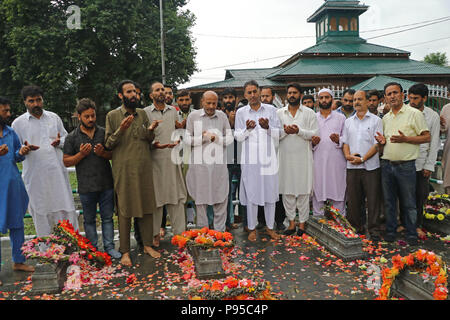 L'Inde. Le 13 juillet, 2018. L'état de Jammu-et-Cachemire Ingénieur Abdul Rasheed législateur, offrir des prières le long-avec ses partisans au cimetière des Martyrs à Srinagar, au Cachemire sous contrôle indien, vendredi 13 juillet, 2018. Le 13 juillet est célébrée comme Journée des martyrs en mémoire de la journée lorsque le roi hindou de la région a commandé plus de 20 musulmans du Cachemire exécuté dans une soumission pour mater une insurrection en 1931.Chaque année, le gouvernement local dans la région observe l'occasion de se souvenir de ces martyrs en visitant leur cimetière et portant des couronnes de fleurs sur leurs tombes Crédit : Umer Asif/Pacific Press/Alamy Live News Banque D'Images