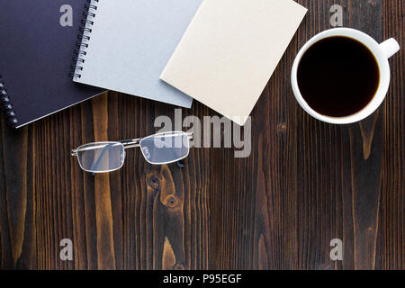 Tasse de café blanc avec du café noir ,les ordinateurs portables et les verres sur la table en bois. Banque D'Images