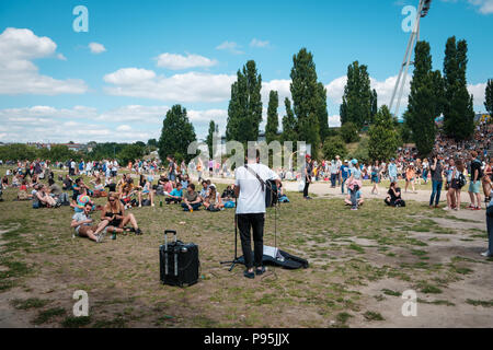 Berlin, Allemagne - juillet 2018 : Musicien chantant et jouant de la guitare dans le parc Mauerpark (bondé) sur une journée ensoleillée à Berlin, Allemagne Banque D'Images