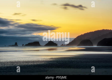 Crépuscule à Cannon Beach avec littoral et mer silhouette stacks, côte de l'Oregon, USA. Banque D'Images