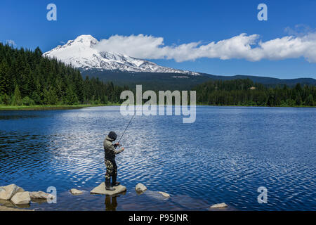 Pêche pêcheur au Trillium Lake sur un beau jour de début de l'été avec le Mt. Le capot à l'arrière-plan, Oregon, USA. Banque D'Images