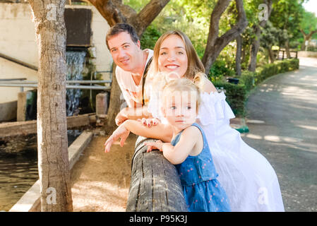 Happy Family - parents avec bébé fille enfant s'amusant dans le zoo. Loisirs en famille, passer du temps ensemble. Focus sélectif. Copy space Banque D'Images