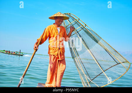 INLE, MYANMAR - février 18, 2018 ; les pêcheurs birmans avec palettes et net est de poser sur le bord de son kayak, le 18 février dans la région de Mandalay. Banque D'Images