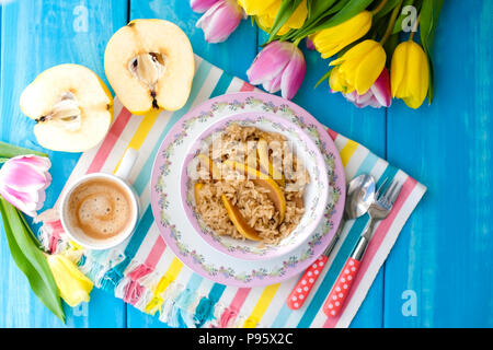 Gruau aux fruits et aromatiques du café le matin pour le petit-déjeuner. Fond bleu et tulipes.. Copy space Banque D'Images