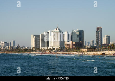 Alma Plages bondés de gens avec Tel Aviv skyline en arrière-plan Banque D'Images