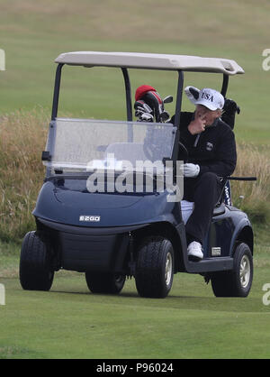 Le président américain, Donald Trump conduit une voiturette de golf sur son terrain de golf à l'Atout Turnberry Resort Ayrshire du Sud, où lui et sa femme Melania, passé le week-end dans le cadre de leur visite au Royaume-Uni avant de partir pour la Finlande où il rencontrera le chef russe Vladimir Poutine pour des entretiens lundi. Banque D'Images