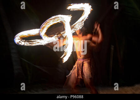 Danseuse polynésienne à l'aide de poteau de flamme sur fond noir Banque D'Images