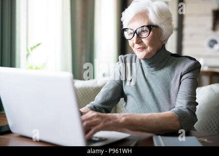 Senior woman typing on laptop Banque D'Images