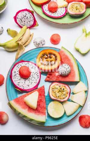 La plaque avec de l'été divers panneaux colorés de fruits tropicaux et fruits rouges sur fond blanc, vue du dessus. Concept de vie propre et sain Banque D'Images