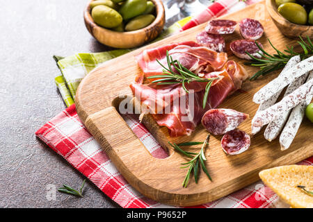 L'antipasto. La viande en tranches, jambon, salami olives sur planche de bois Banque D'Images