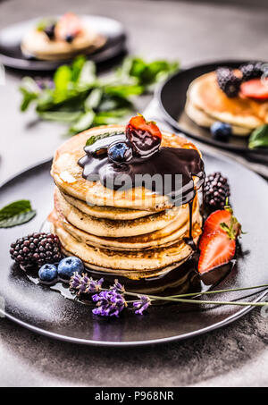 Crêpes aux fraises myrtilles mûres feuilles de menthe lavande et chocolat chaud. Banque D'Images