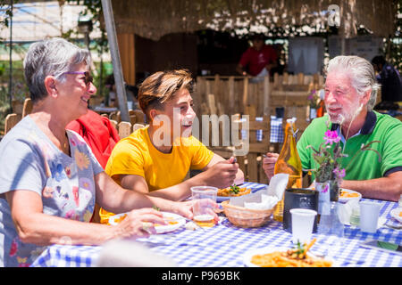 Les personnes de race blanche de la famille avec grand-mère grand-père petit-fils manger ensemble dans l'alternative naturelle place restaurant appréciant le repas et le vegeta Banque D'Images