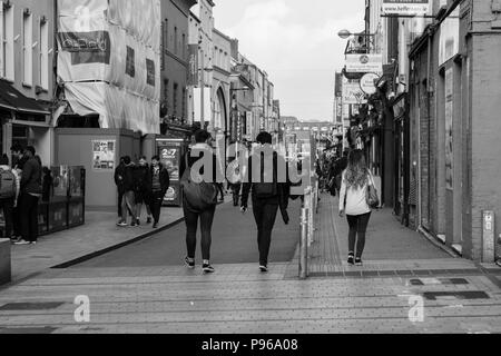 Cork, Irlande - les gens du shopping sur la rue Patrick, la rue principale pour les magasins, artistes de rue, des restaurants ; photographié en monochrome. Banque D'Images