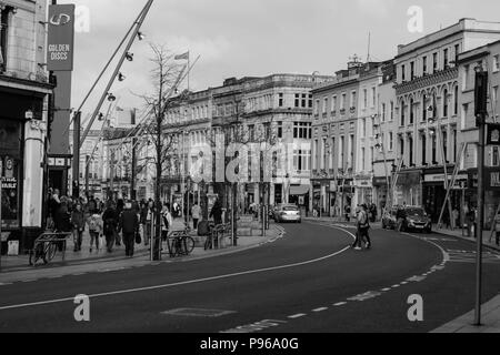 Cork, Irlande - les gens du shopping sur la rue Patrick, la rue principale pour les magasins, artistes de rue, des restaurants ; photographié en monochrome. Banque D'Images