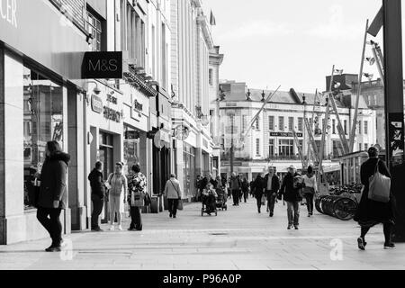 Cork, Irlande - les gens du shopping sur la rue Patrick, la rue principale pour les magasins, artistes de rue, des restaurants ; photographié en monochrome. Banque D'Images