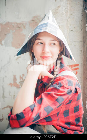 Portrait of young smiling woman in journal hat. Réparation accueil concept. Banque D'Images