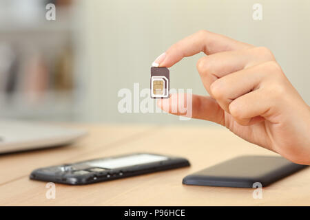 Close up of a woman holding carte sim différentes tailles à la maison Banque D'Images